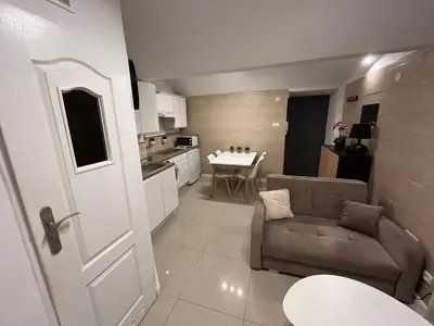 a small living room with a couch and a kitchen at A&J Apartments in Kraków