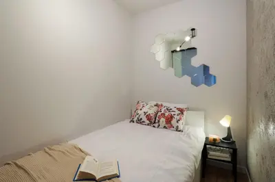 a bedroom with a bed with a book on it at Malila Premium Apartments Cracow Limanowskiego 37 in Kraków
