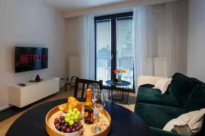 a living room with a green couch and a table with fruit at Malila Premium Apartments Cracow Limanowskiego 37 in Kraków