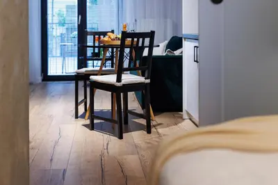 a kitchen with two chairs and a table with fruit on it at Malila Premium Apartments Cracow Limanowskiego 37 in Kraków