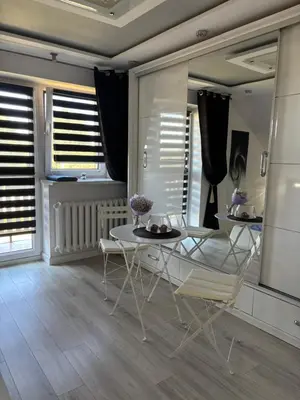a dining room with a table and chairs and windows at Rooms near Balice airport in Cholerzyn