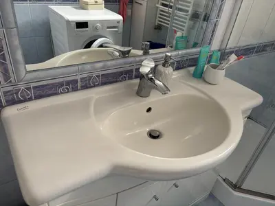 a white sink in a bathroom with a mirror at Rooms near Balice airport in Cholerzyn