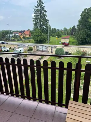 a balcony with a bench and a view of a parking lot at Rooms near Balice airport in Cholerzyn