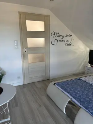 a bedroom with a door and a bed and a table at Rooms near Balice airport in Cholerzyn