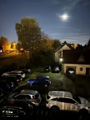 a group of cars parked in a parking lot at night at Rooms near Balice airport in Cholerzyn