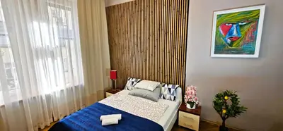 a bedroom with a blue bed and a painting on the wall at Old Town KRAKÓW STUDIO in Kraków