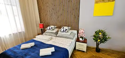 a bedroom with a bed with blue sheets and pillows at Old Town KRAKÓW STUDIO in Kraków
