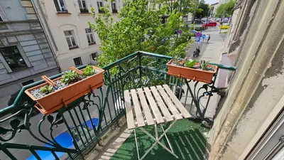 a balcony with two potted plants and a wooden bench at Old Town KRAKÓW STUDIO in Kraków
