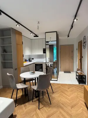 a kitchen and living room with a table and chairs at Mieszkanie do wynajęcia Rydlówka Kraków in Kraków