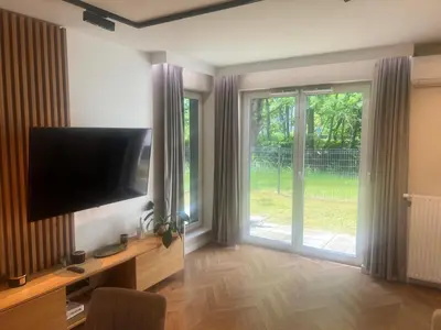 a living room with a television and a sliding glass door at Mieszkanie do wynajęcia Rydlówka Kraków in Kraków