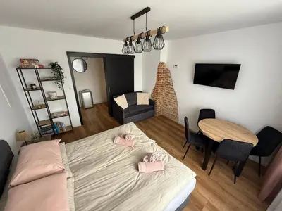 a bedroom with a bed and a dining room table at Apartament Grojec in Grojec