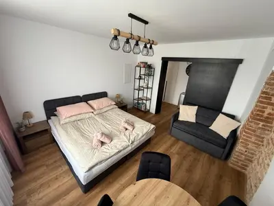 a bedroom with a bed and a chair and a table at Apartament Grojec in Grojec
