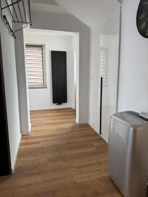 an empty living room with white walls and wood floors at Apartament Grojec in Grojec