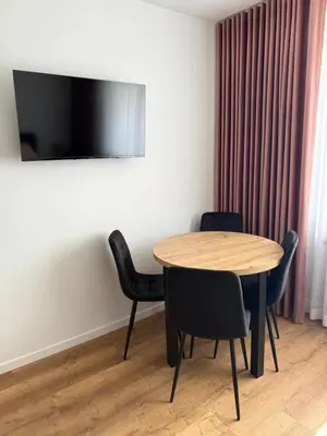 a table and chairs in a room with a television at Apartament Grojec in Grojec