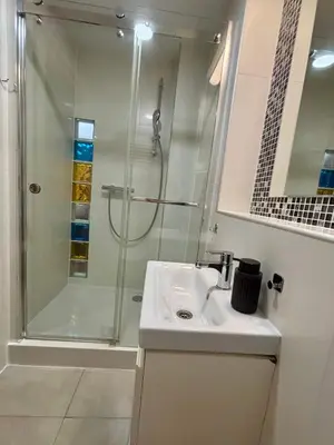 a white bathroom with a shower and a sink at Vintage Studencka 25 Apartment in Kraków