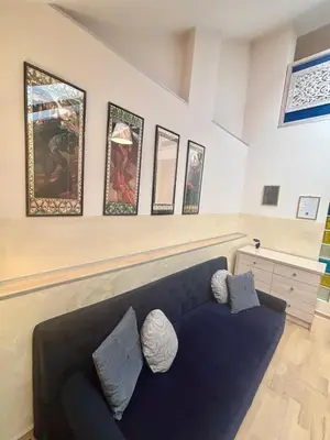 a living room with a blue couch and pictures on the wall at Vintage Studencka 25 Apartment in Kraków