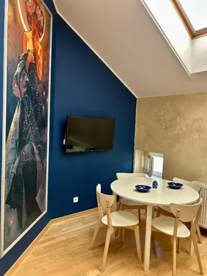 a dining room with a white table and a painting at Vintage Studencka 25 Apartment in Kraków
