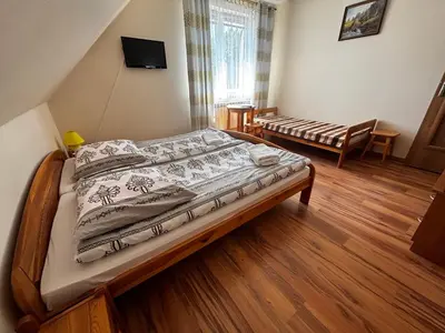 a bedroom with a bed and a chair at Noclegi Pod Lasem in Zubrzyca Górna