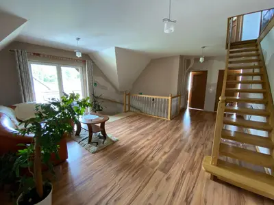 a living room with a staircase and a table at Noclegi Pod Lasem in Zubrzyca Górna