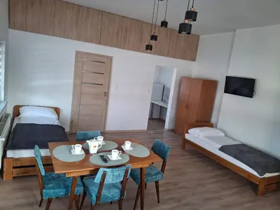 a room with a table and chairs and a bed at Mieszkanie Paszkówka in Paszkówka