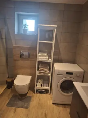 a bathroom with a toilet and a washing machine at Mieszkanie Paszkówka in Paszkówka