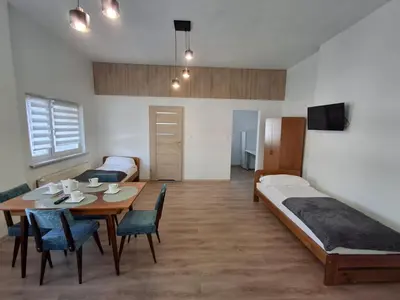 a room with a table and a bed and a bedroom at Mieszkanie Paszkówka in Paszkówka