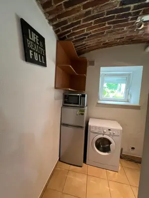 a kitchen with a washing machine and a microwave at Kawalerka,studio underground in Kraków