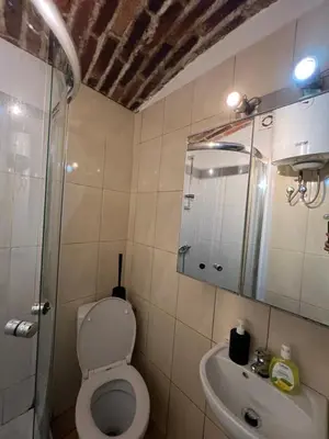 a bathroom with a toilet and a sink and a mirror at Kawalerka,studio underground in Kraków