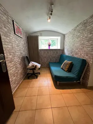 a living room with a blue couch and a window at Kawalerka,studio underground in Kraków