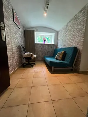 a living room with a blue couch and a window at Kawalerka,studio underground in Kraków