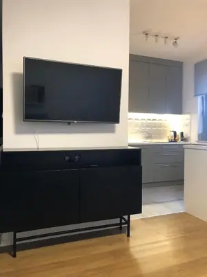 a living room with a flat screen tv on a wall at Komfortowy apartament blisko Tauron Areny in Kraków