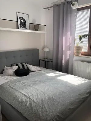 a bedroom with a large bed with a window at Komfortowy apartament blisko Tauron Areny in Kraków