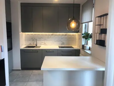 a kitchen with gray cabinets and a white counter top at Komfortowy apartament blisko Tauron Areny in Kraków