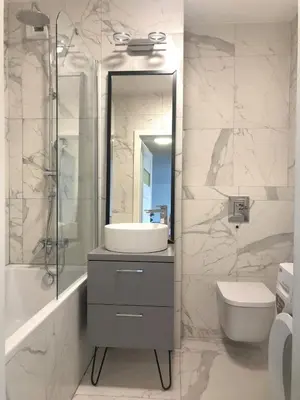 a bathroom with a sink and a toilet and a mirror at Komfortowy apartament blisko Tauron Areny in Kraków
