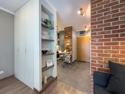 a living room with a brick wall and a couch at Apartament Śliwka w Krakowie in Kraków