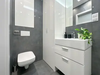 a bathroom with a white toilet and a sink at Apartament Śliwka w Krakowie in Kraków