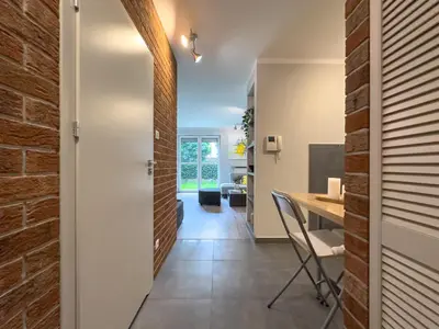 a hallway with a brick wall and a desk in a house at Apartament Śliwka w Krakowie in Kraków