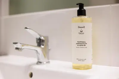 a bottle of liquid soap sitting on a bathroom sink at Malila Premium Apartments Łaszkiewicza 8 -Tauron Arena Parking in Kraków