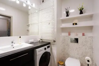 a bathroom with a sink and a toilet and a mirror at Malila Premium Apartments Łaszkiewicza 8 -Tauron Arena Parking in Kraków
