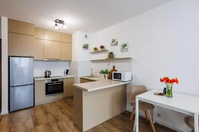 a kitchen with white cabinets and a counter top at Malila Premium Apartments Łaszkiewicza 8 -Tauron Arena Parking in Kraków