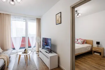 a living room with a couch and a tv and a mirror at Malila Premium Apartments Łaszkiewicza 8 -Tauron Arena Parking in Kraków