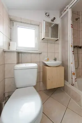 a bathroom with a white toilet and a sink at Love Bridge Apartments in Kraków