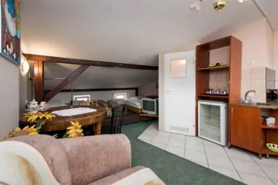 a kitchen and a living room with a couch and a table at Love Bridge Apartments in Kraków