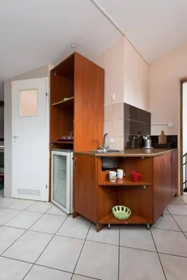 a large kitchen with wooden cabinets and a counter at Love Bridge Apartments in Kraków