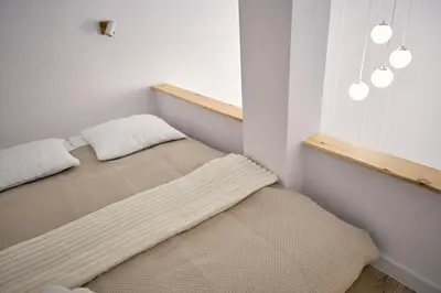 a bed in a room with two pillows on it at MIYABI Apartment in Kraków