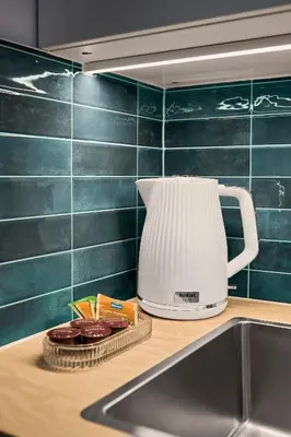 a white blender sitting on a counter next to a sink at MIYABI Apartment in Kraków