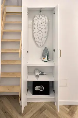 a walk in closet with white shelving and stairs at MIYABI Apartment in Kraków