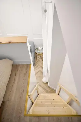 a room with a bed and a mirror on the floor at MIYABI Apartment in Kraków