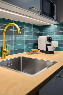 a kitchen counter with a sink and a toaster at MIYABI Apartment in Kraków