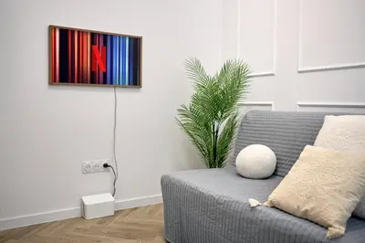 a living room with a couch and a painting on the wall at MIYABI Apartment in Kraków
